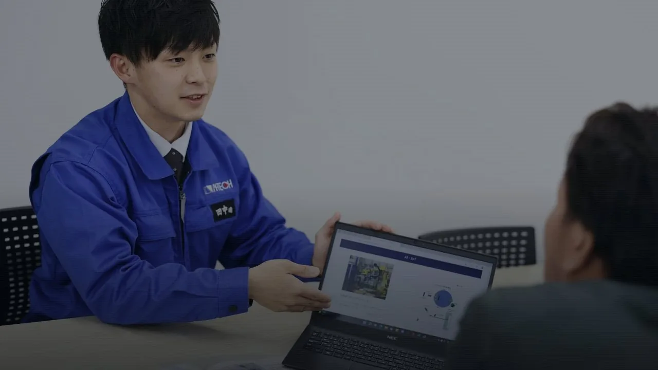 打ち合わせで図面を示すエヌテックの社員